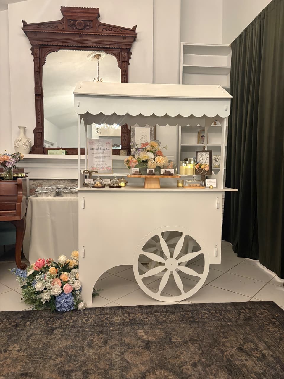 Sweet Alchemy’s handcrafted white fudge cart dressed with flowers and a display of fudge